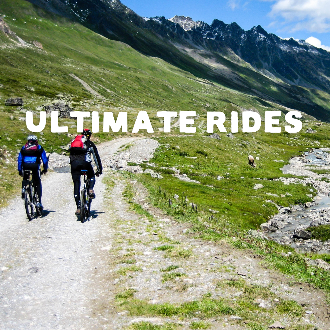 People cycling along a gravel track with mountains in the background. With The text Ultimate Rides