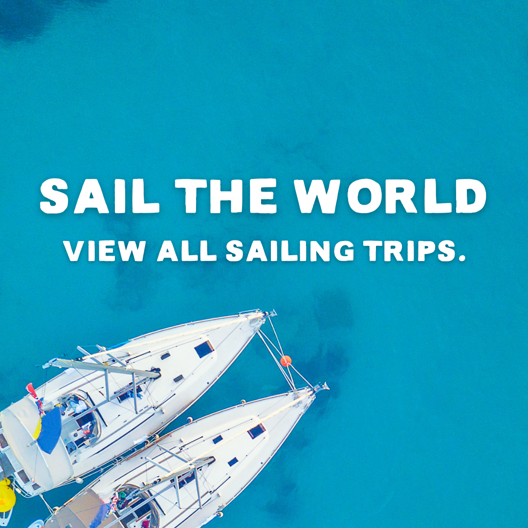 Two ships in the corner of the photo with the text Sail the world - View all sailing trips