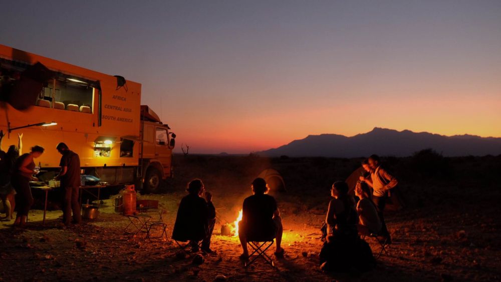 People sat around the warm glow of a campfire