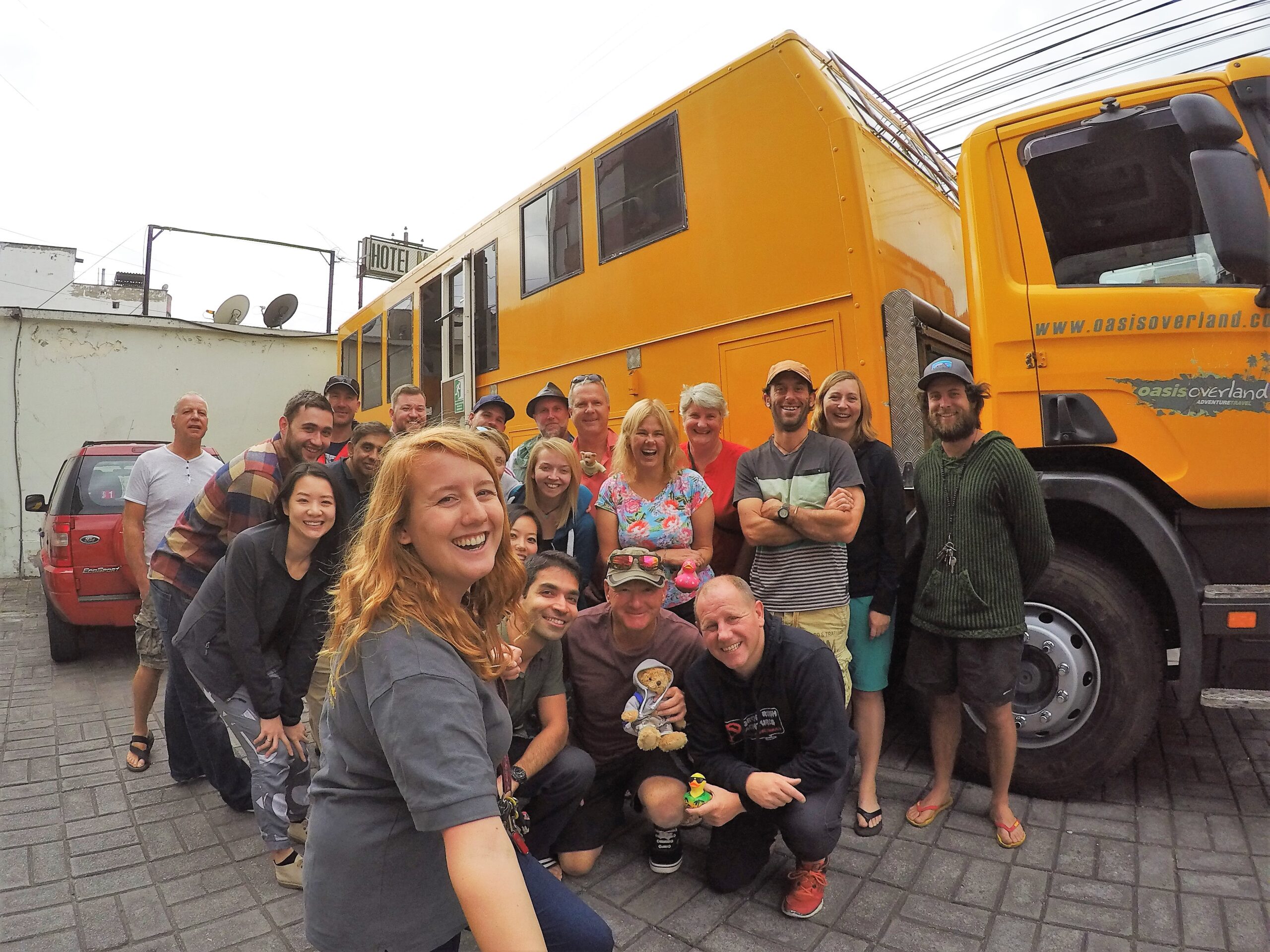 A group selfie shot with a large orange truck